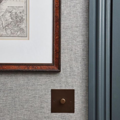 Woven Fabric Wall Panel with Bronze Dimmer Switch Plate